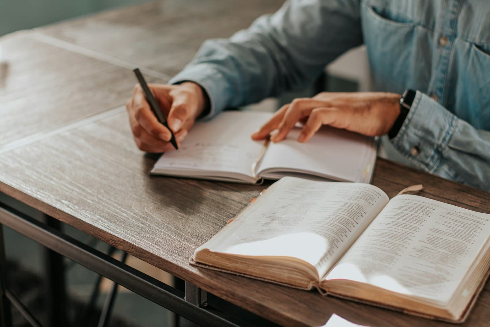 Two people working through the same ruled notebook at one table